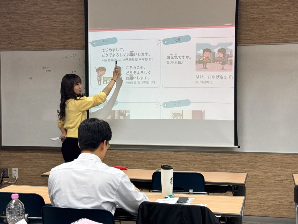 일본어 수업에서 교재 화면을 설명하는 강사